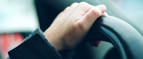 יד נשית אוחזת בהגה מכונית