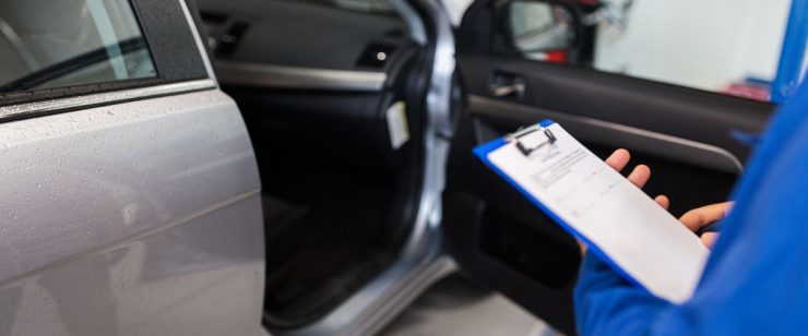 אדם עורך בדיקה לרכב