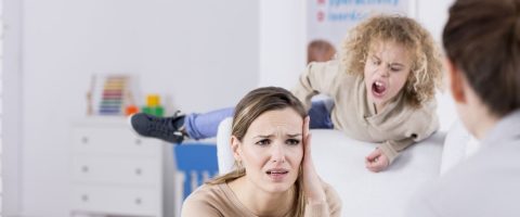 ילד משתולל ואמו אוחזת את ראשב בתסכול