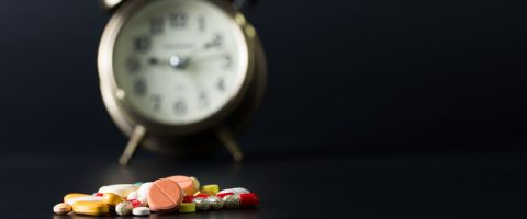 שעון מעורר ותרופות על רקע שחור