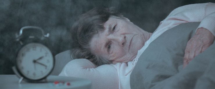 אישה מבוגרת שוכבת ובוהה על המיטה