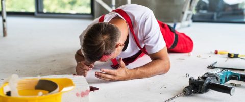 עובד רכון על הרצפה כשפניו מכוסות בדם